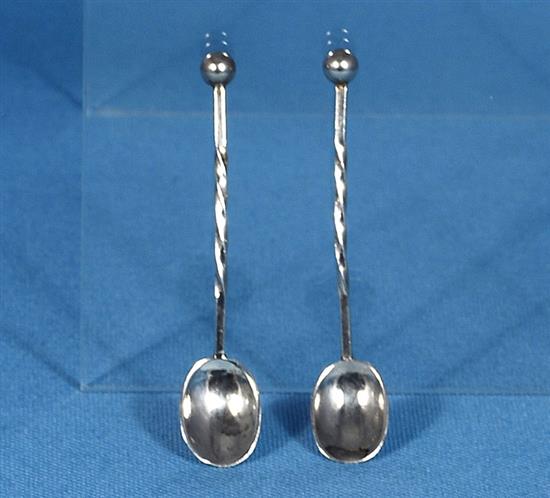 A pair of George V Arts & Crafts silver mustard pots with matching spoons, by Albert Edward Jones, width 90mm, weight 5.1oz/160grms.